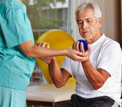 therapist helping a patient holdin a ball